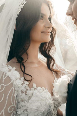 Vestido de novia blanco de corte A con escote corazón y mangas largas, con encaje.