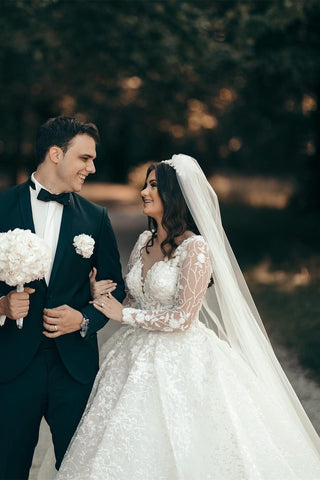 Vestido de novia blanco de corte A con escote corazón y mangas largas, con encaje.