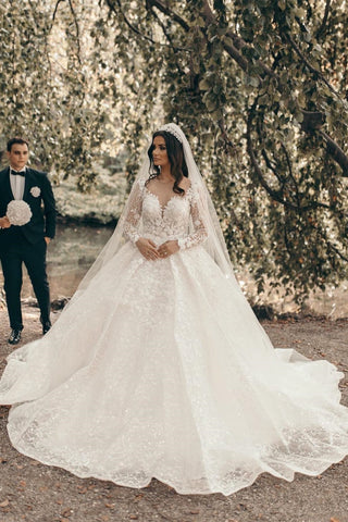 Vestido de novia blanco de corte A con escote corazón y mangas largas, con encaje.