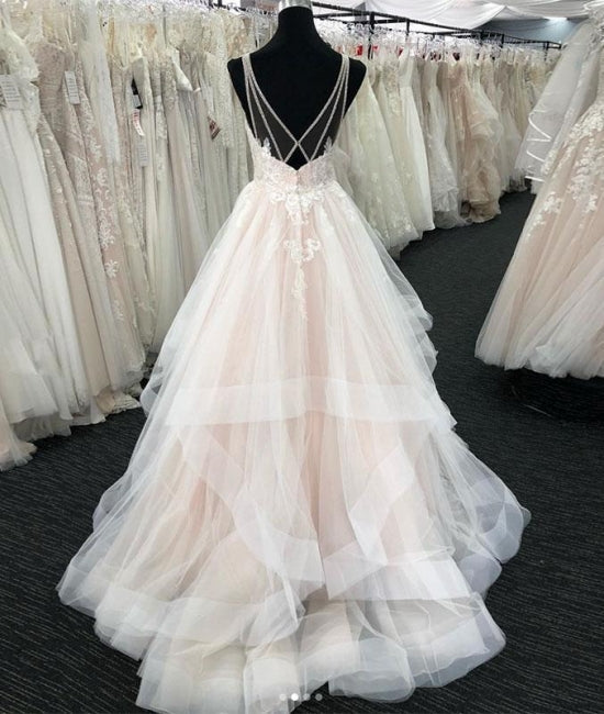 Robe de mariée longue à volants en tulle blanc, col en V et dos nu. 