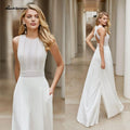 Vestido de novia blanco estilo bohemio, con cuello redondo y largo hasta el suelo. Incluye un mono de novia blanco y detalles de encaje personalizables.