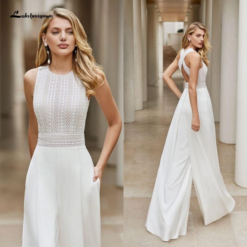 Vestido de novia blanco estilo bohemio, con cuello redondo y largo hasta el suelo. Incluye un mono de novia blanco y detalles de encaje personalizables.